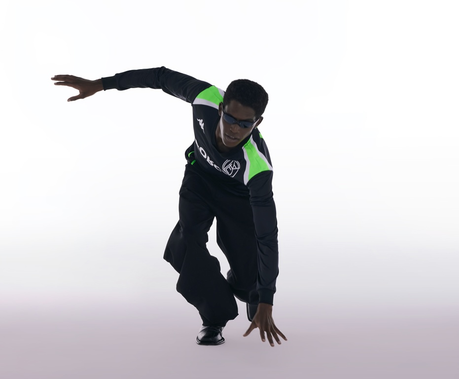 Kappa x Forca Studio - Modelo em pose dinâmica usando tracksuit da colaboração com detalhes em verde
